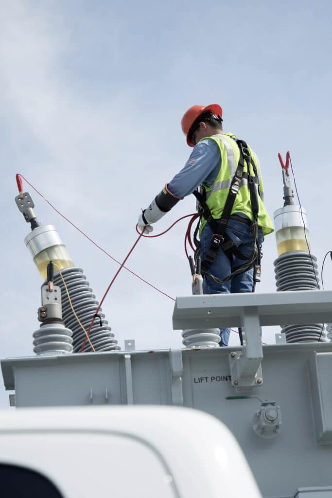 man working on high voltage power lines transformer